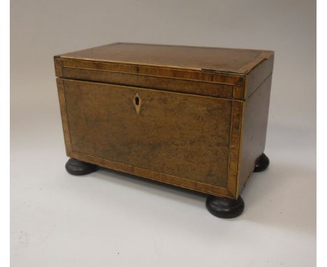 A 19th Century walnut and cross banded tea caddy, the lid opening to reveal two compartments with rosewood covers