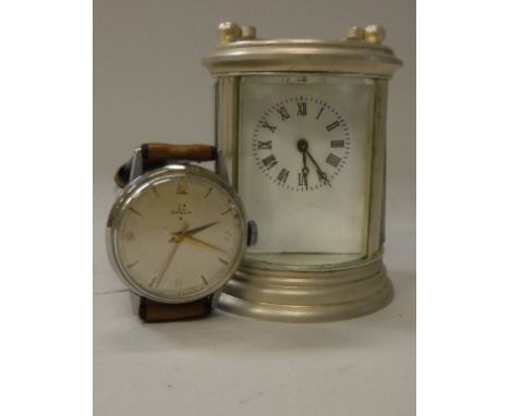 A modern carriage clock of circular form, the white dial set with Roman numerals, together with an Omega watch, the brushed s