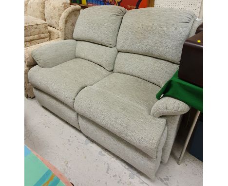 A modern reclining two seat sofa with pale green upholstery