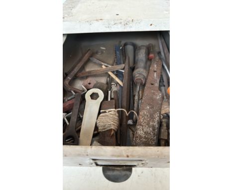 Vintage metal workshop drawers filled with assorted hand tools, including wrenches, files, saws, and drill bits.