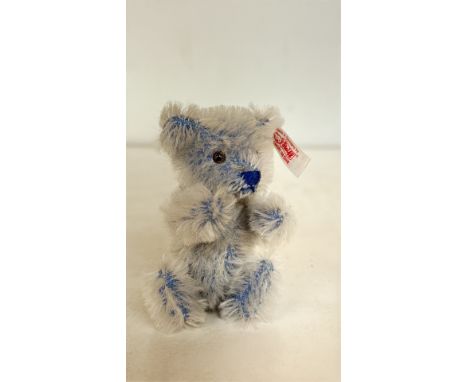 Steiff miniature mohair teddy bear, made in Germany, features blue accents, jointed limbs, glass eyes, and signature "Knopf i