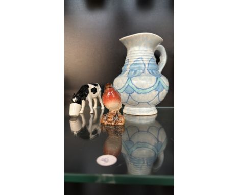 Hand-painted Shebeg porcelain cow by K.A. Mooney, Isle of Man, an artisan-glazed pottery jug, and a ceramic robin figurine.