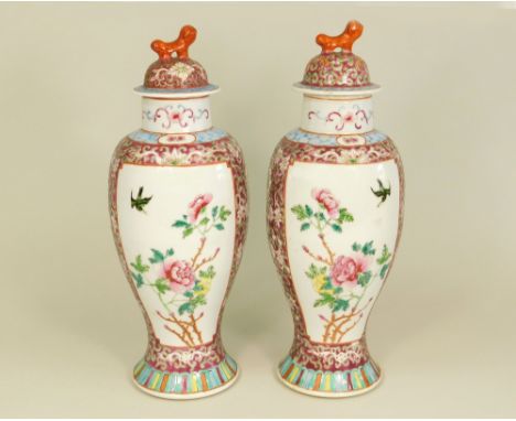 CHINESE VASES.A pair of early 20th century polychrome enamel vases, each with two panels of birds & flowers. Full height 30cm