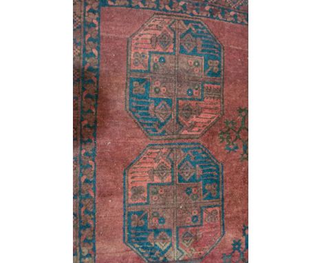 Afghan pattern small carpet, with three rows of tiles on a red ground, geometric borders, 330cm x 225cm.
