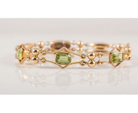 A peridot bracelet, the four rectangular peridot individually collet set in a yellow metal bracelet stamped 15ct, and spaced 
