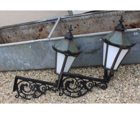 Pair of Iron Framed Street Lanterns each held on an Iron Wall Bracket with a Bird Design