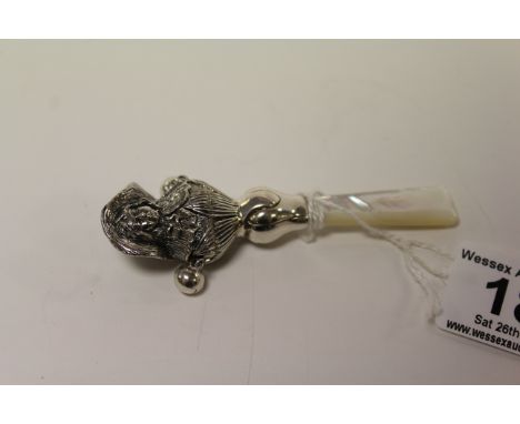 A silver babies rattle with mother of pearl handle.