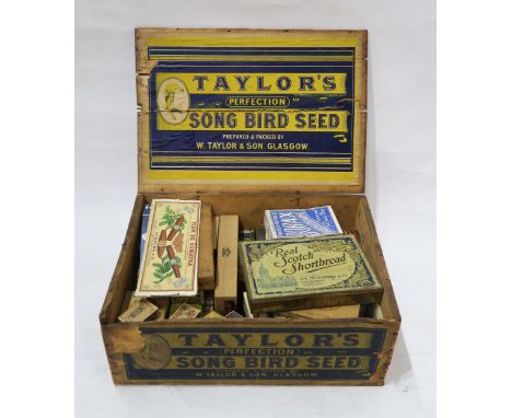 A pine advertising crate for Taylor's of Glasgow's Perfection Song Bird Seed, containing an assortment of vintage tins and pa