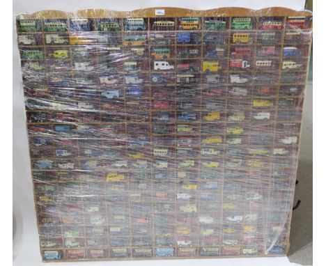 A substantial collection of scale model advertising vans, cars and buses, housed in a purpose-built wall-mounted display case