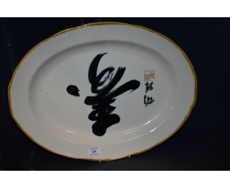 A modern ceramic serving plate of oval form with an Oriental design