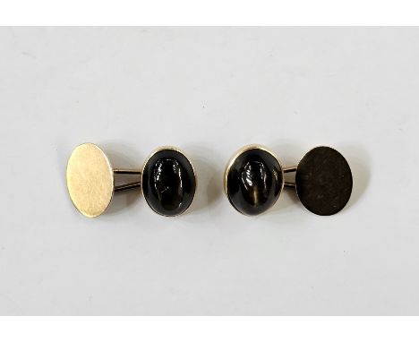 Pair of gold-coloured cufflinks, each set with an oval brown stone cabochon displaying Chatoyancy&nbsp;Condition ReportThe to