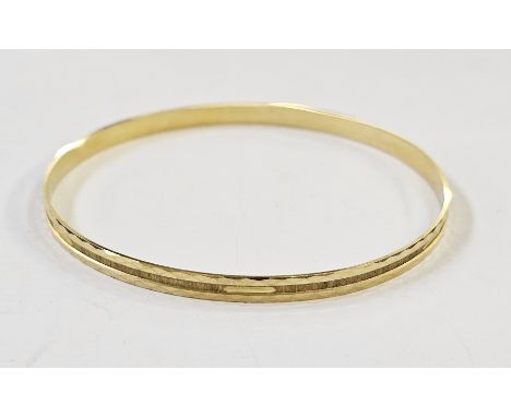 A gold-coloured metal bangle with engraved decoration, marked 333, 8g approx&nbsp;