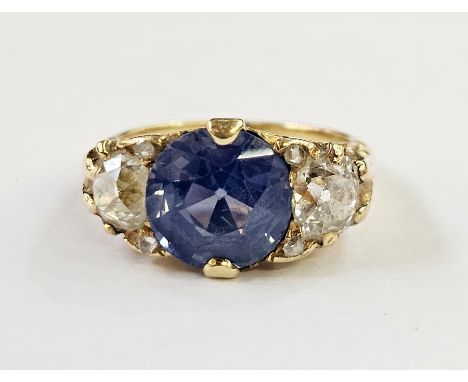 Antique diamond and blue stone dress ring, the circular central stone possibly pale blue sapphire, flanked by two old cut dia