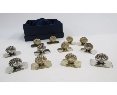 Set of 12 modern silver menu holders modelled as scallop shells, on rectangular bases with chamfered corners, each 3cm long, 