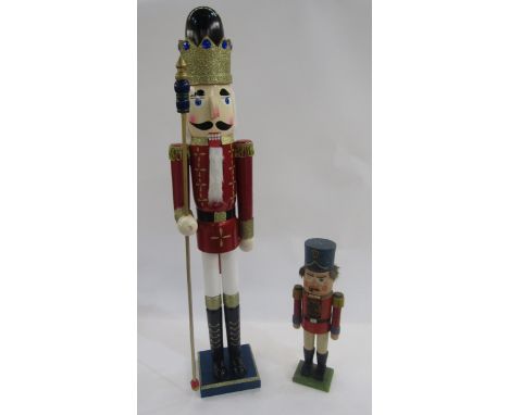 Large painted wooden Christmas soldier nutcracker with moveable mouth, 86cm high, and another smaller, 37cm high (worn).