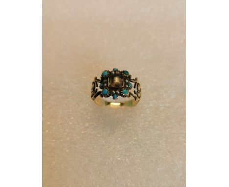 A mid-19th century mourning ring, the central glazed hair panel within a border of turquoise and seed pearls.