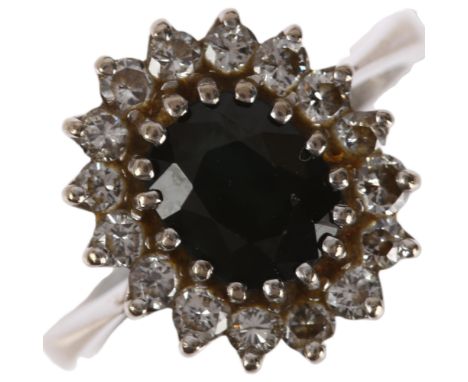 A late 20th century 18ct white gold sapphire and diamond oval cluster ring, London 1974, claw set with oval mixed-cut sapphir