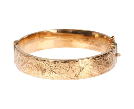 A mid-20th century 9ct gold hinged bangle, maker S&P, Birmingham 1963, with engraved foliate decoration, band width 13.2mm, i