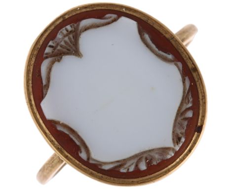 An Antique sardonyx shield cameo ring, unmarked gold settings with relief carved panel depicting vacant shield with floral en