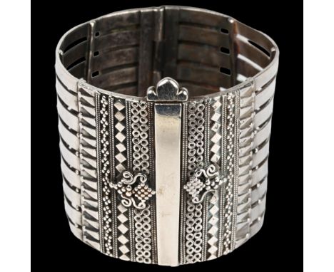 A heavy Ethnic Tribal cuff hinge bangle, apparently unmarked silver, length 53.7mm, diameters 59.5mm and 54.2mm, 143.5gNo dam