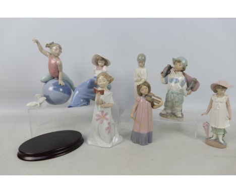 A collection of Nao figures of children including boy with a skateboard, girl with violin and other, largest approximately 21