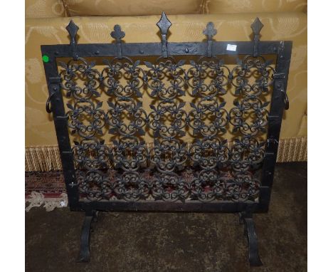 A mid 20th century wrought iron fireguard with pierced foliate scrolls, shaped bar feet, 80cm h x 73cm w