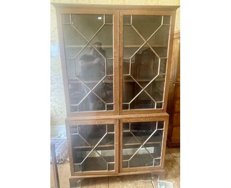 A Chippendale design oak glazed bookcase, out-swept cornice above two astragal glazed doors enclosing line fitted adjustable 