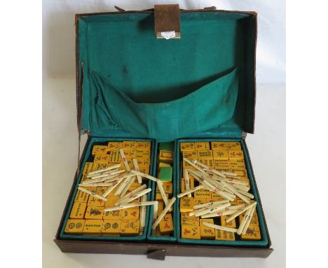 A 1930s Mahjong set, the counters with simulated jade backs, together with bone counters and miniature dice contained in a le