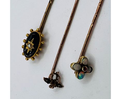 A trio of stick pins (testing as 9ct gold). One shaped as a small insect and set with seed pearls, missing the primary stone,