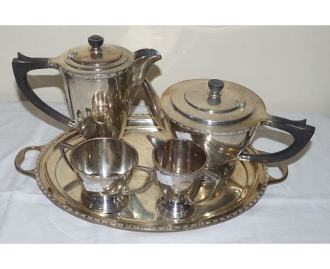 A silver five piece tea and coffee service with cast band, engraved monogram and stepped circular base, comprising teapot, co