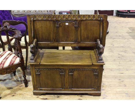 Carved oak monks bench with lion arms, 73cm by 107cm (closed).