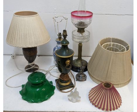 A mixed lot of lamps to include a Victorian brass oil lamp, a carved and gilt example, a Chinese style blue and white vase la