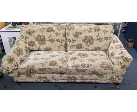 A parker Knoll sofa having floral upholstery and front feet raised on castors, 83cm h x 206cm wLocation:If there is no condit