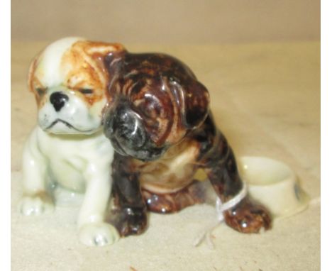 A Royal Worcester model of bulldog puppies CONDITION REPORT: There is a minor chip to the right paw of the brown dog next to 