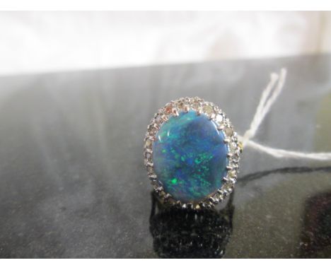 An 18ct large "Millionaires Gully" Australian mined black opal ring with Diamond surround
