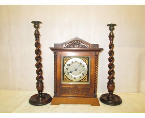A late 19th century German mantle clock; together with a pair of oak candlesticks