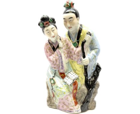 Oriental ceramic figure modeled as a woman reading with a man stood behind her, with stamped mark beneath H39cm.  