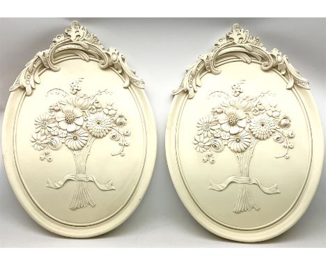 Pair of ceramic wall plaques each decorated in relief with scroll detail and ribbon-tied flowers, H72.5cm