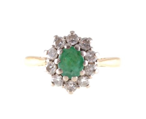 An emerald and diamond oval cluster ring, the oval mixed cut emerald claw set and surrounded by ten brilliant cut diamonds in