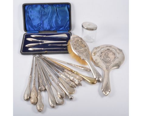 A collection of fourteen button hooks, all silver coloured handles, some hallmarked, a silver backed hand brush and mirror, s