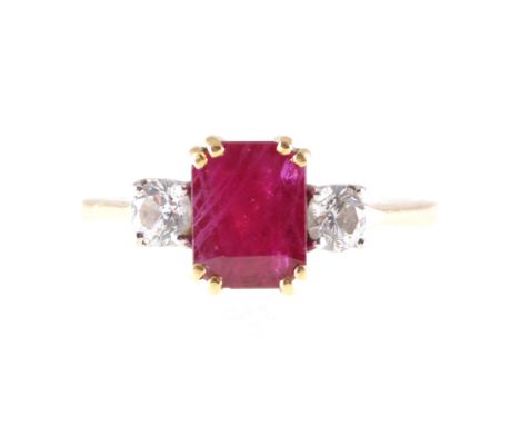 A ruby and diamond three stone ring, a rectangular step cut ruby 7.8mm x 5.8mm set with four corner claws, with a brilliant c