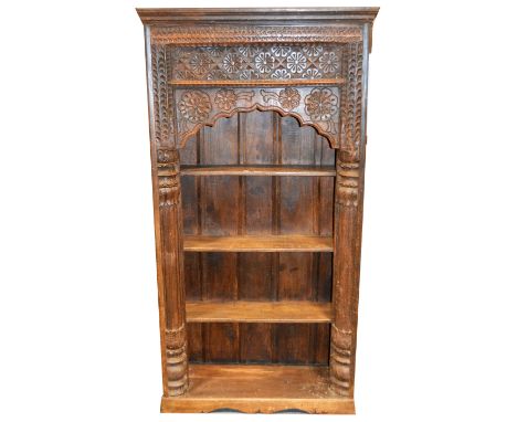 A Moroccan style hardwood bookcase, carved arched panel and columns, enclosing three shelves, W104cm x D40cm x H197cm.