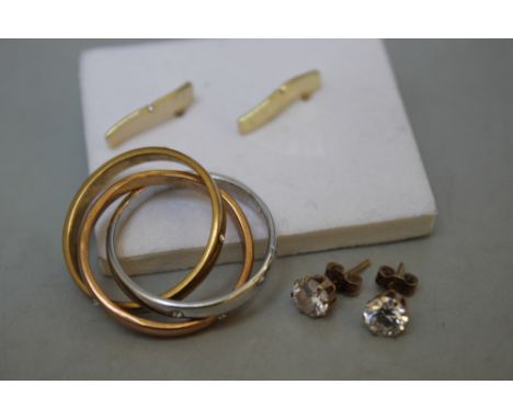 A SELECTION OF YELLOW METAL AND OTHER JEWELLERY, comprising a three colour puzzle ring and two pairs of earrings