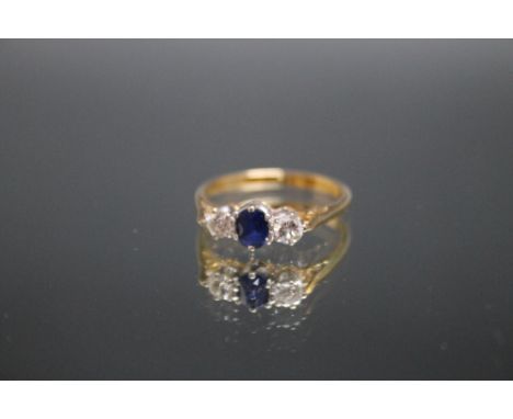 AN 18CT GOLD SAPPHIRE AND DIAMOND THREE STONE RING, the brilliant cut diamonds being an estimated 0.15 carat each, ring size 