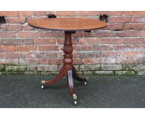 A GEORGE III MAHOGANY TILT TOP PEDESTAL TABLE, the one piece circular top with original snap lock mechanism, raised on a balu