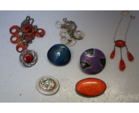 A SMALL CIRCULAR RUSKIN STYLE BROOCH, unmarked example, together with a selection of ceramic panel brooches, a mother of pear