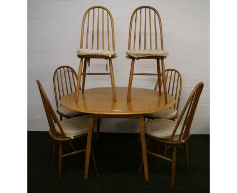 An Ercol style suite of elm dining furniture, comprising a circular drop-leaf table and six chairs CONDITION REPORT; Approxim