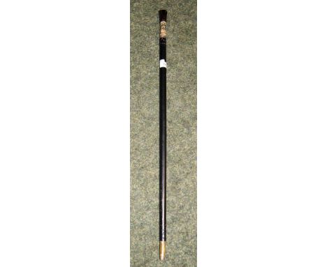 An ebonised cased sword stick, early 20th Century, with carved horn grip and brass lion-mask pommel. Approximately 58cm long