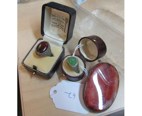 A silver coloured ring with jade inset, another gem set ring and an agate brooch