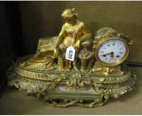 A gilt metal mantel clock reclining lady on chaise longue